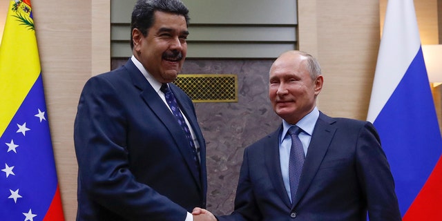 Presiden Rusia Vladimir Putin berjabat tangan dengan Presiden Venezuela Nicolas Maduro