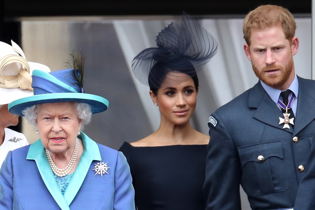Ratu Elizabeth II, Pangeran Harry, Duke of Sussex dan Meghan, Duchess of Sussex di balkon Istana Buckingham saat keluarga kerajaan menghadiri acara untuk merayakan seratus tahun RAF pada 10 Juli 2018 di London, Inggris. 