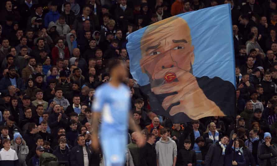 Suporter Manchester City mengibarkan bendera pelatih Pep Guardiola.