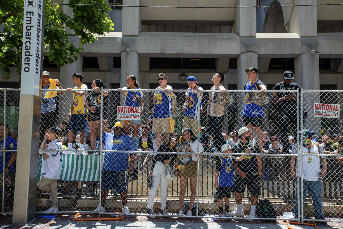 Fans berdiri di rel kereta api untuk menonton aksi selama Parade Kejuaraan Golden State Warriors di Market Street di San Francisco, California pada 20 Juni 2022.