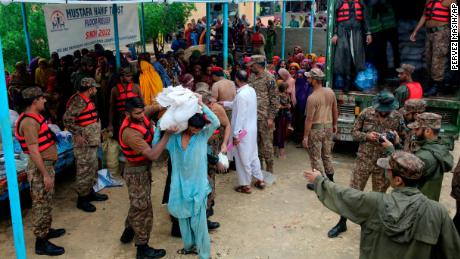 Pasukan tentara mendistribusikan makanan dan pasokan kepada orang-orang terlantar di sebuah kamp bantuan di distrik Jamshoro, Pakistan selatan, pada 24 Agustus.