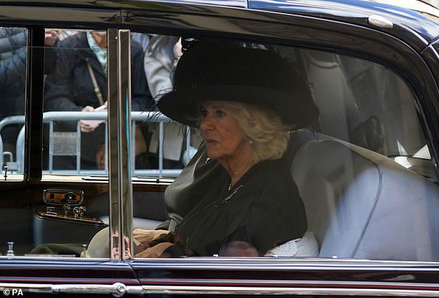 Camilla, 75, tampak emosional saat mengikuti prosesi peti mati Ratu Elizabeth dengan mobil dari Istana Holyrood ke Katedral St Giles hari ini.
