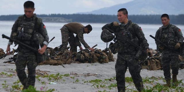 Korsel (depan) dan Marinir AS berpartisipasi dalam latihan pendaratan amfibi bersama dengan rekan-rekan Filipina mereka di pantai yang menghadap ke Laut Cina Selatan di San Antonio, Provinsi Zambales, 7 Oktober 2022. 