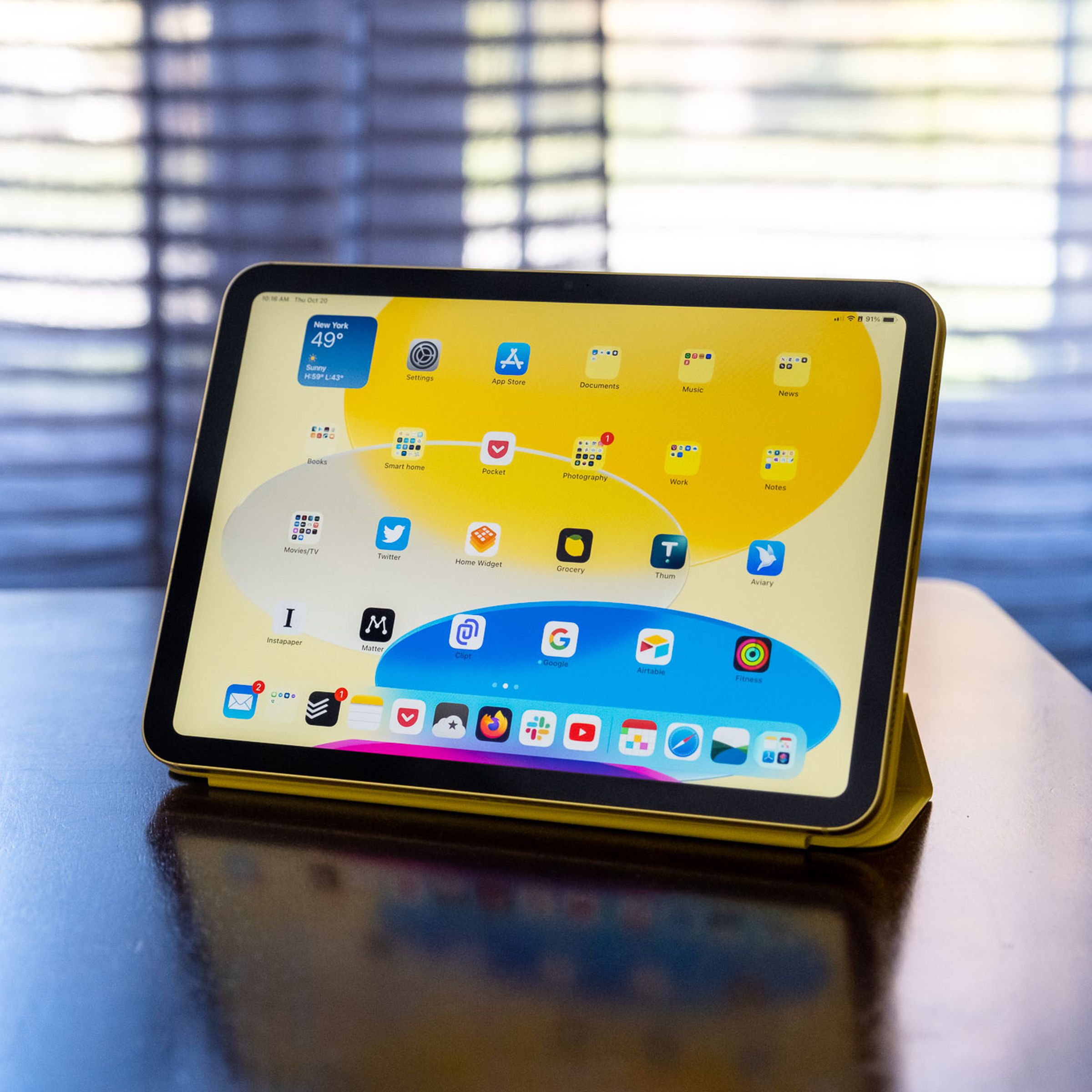 iPad generasi ke-10 dalam Apple Smart Folio di atas meja kayu.