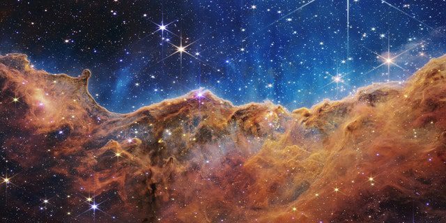 Apa yang tampak sangat mirip pegunungan berbatu di malam hari yang diterangi cahaya bulan sebenarnya adalah ujung dari wilayah pembentuk bintang muda NGC 3324 di Nebula Carina.  Diambil dalam cahaya inframerah oleh Kamera Inframerah Dekat (NIRCam) pada Teleskop Antariksa James Webb NASA, gambar ini mengungkapkan wilayah kelahiran bintang yang sebelumnya tertutup.
